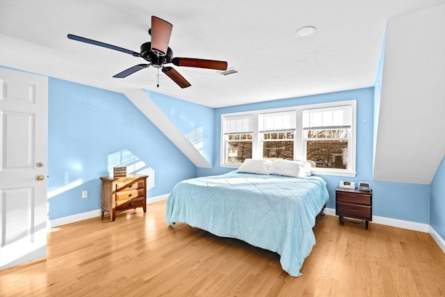 bedroom with ceiling fan, light hardwood / wood-style flooring, and vaulted ceiling