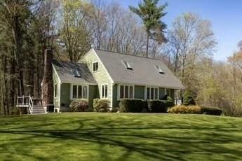 rear view of house featuring a lawn
