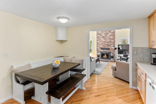 dining room with light wood-style floors, a fireplace, and breakfast area