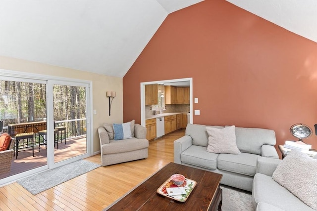 living room featuring light wood-type flooring and high vaulted ceiling
