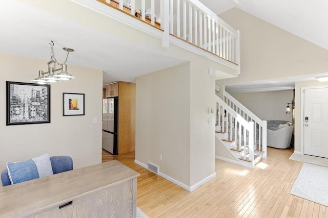 interior space featuring stairs, baseboards, visible vents, and light wood-style flooring