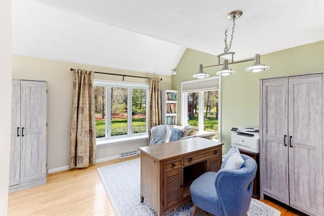 office with baseboards, vaulted ceiling, light wood-style flooring, and visible vents