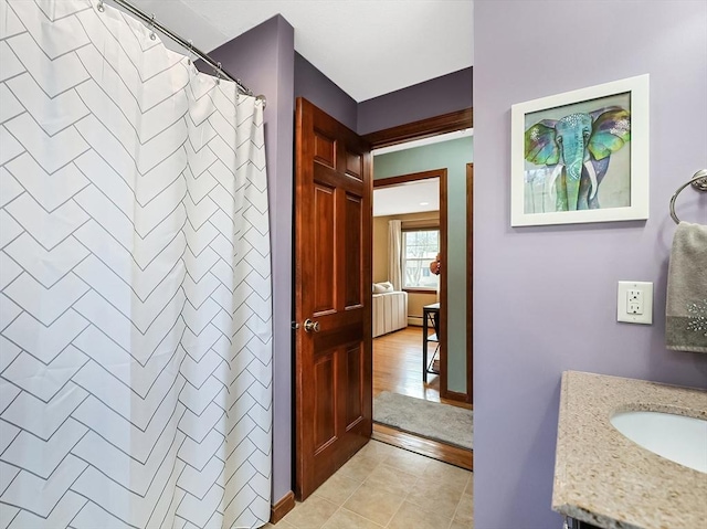 full bath featuring curtained shower, vanity, and tile patterned flooring