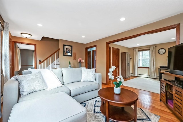 living area with recessed lighting, light wood-style floors, and stairs