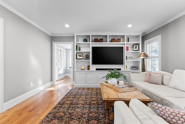 living room with ornamental molding and light hardwood / wood-style floors