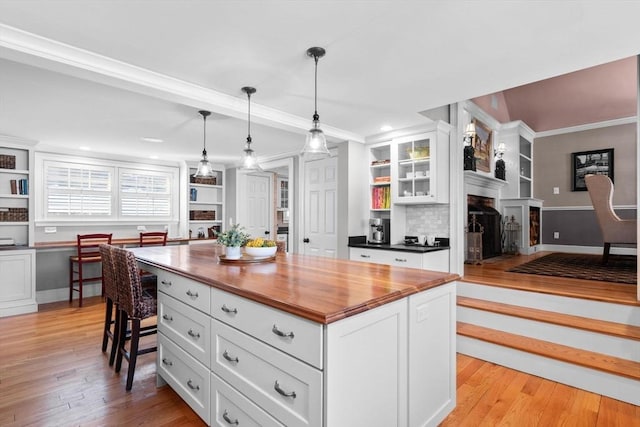 kitchen featuring white cabinetry, pendant lighting, built in desk, and a kitchen island