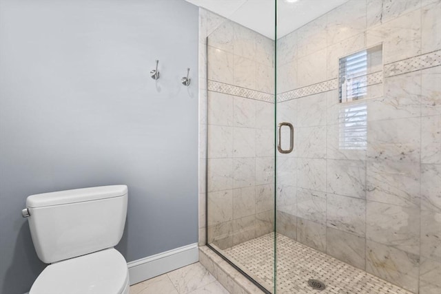 bathroom with a shower with shower door and toilet