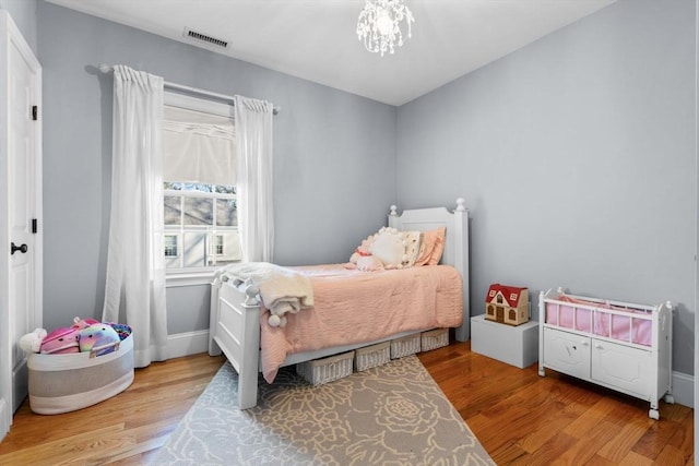 bedroom featuring a notable chandelier and light wood-type flooring