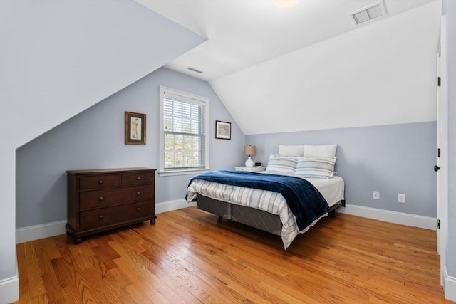 bedroom featuring vaulted ceiling and light hardwood / wood-style flooring