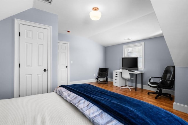 bedroom featuring lofted ceiling and wood-type flooring