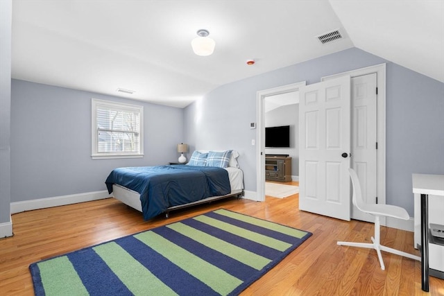 bedroom with lofted ceiling and hardwood / wood-style flooring