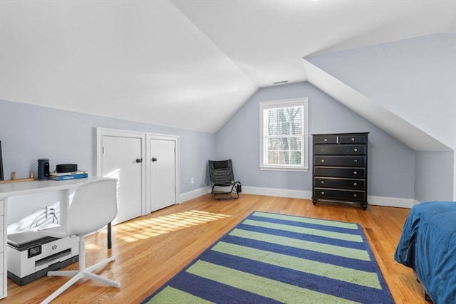 office with lofted ceiling and light hardwood / wood-style flooring