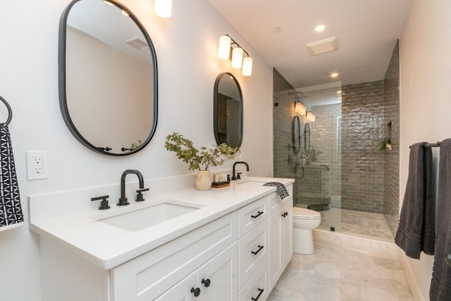 bathroom with vanity, toilet, and tiled shower