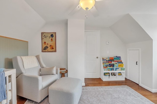 sitting room featuring ceiling fan, wood finished floors, and vaulted ceiling