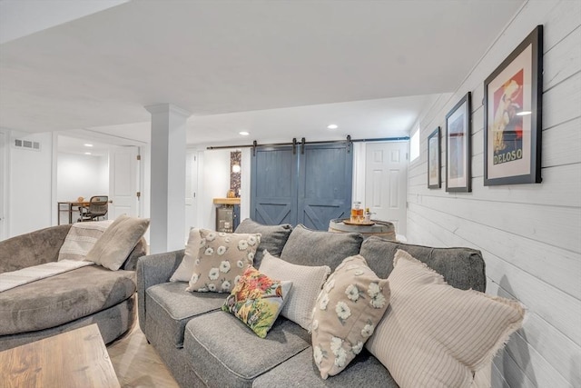 living area with visible vents, recessed lighting, and a barn door