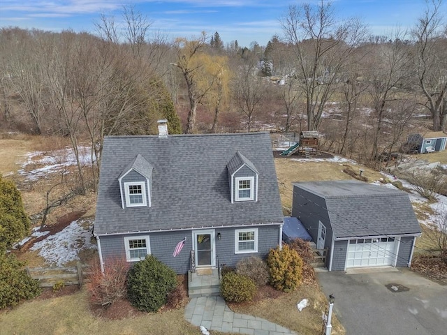 cape cod house with an outbuilding, aphalt driveway, a playground, a shingled roof, and a garage