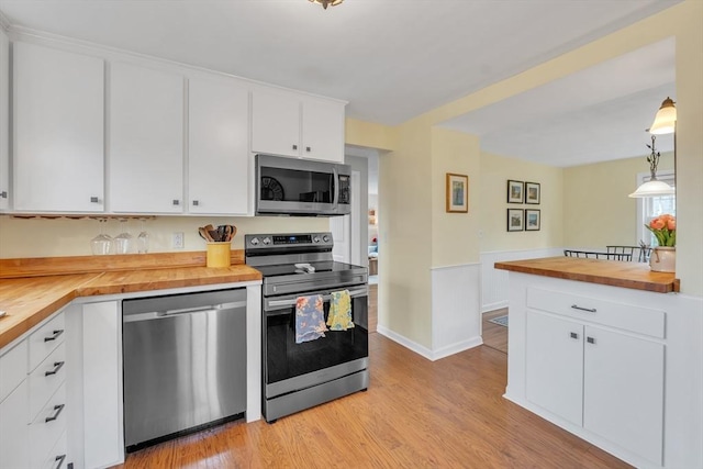 kitchen with white cabinetry, light wood-style floors, appliances with stainless steel finishes, and wood counters