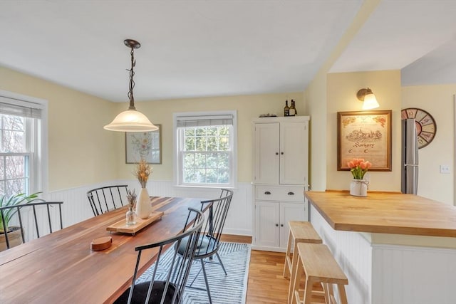 dining space featuring wainscoting and light wood finished floors