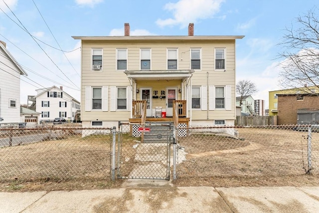 view of front facade with a gate, a chimney, and a fenced front yard