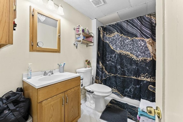 bathroom featuring visible vents, vanity, curtained shower, toilet, and a drop ceiling