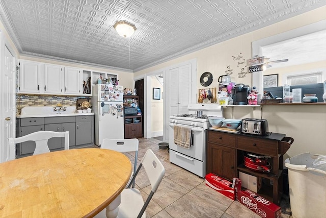 kitchen with an ornate ceiling, white appliances, tasteful backsplash, and white cabinets
