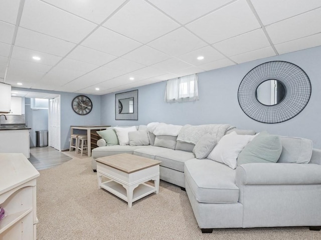 living area featuring recessed lighting, light colored carpet, and a paneled ceiling