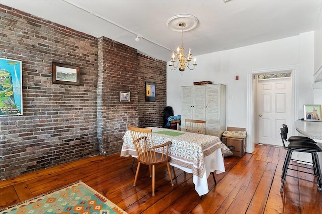 6 Brigham St Unit 2, Boston, MA 02128 - dining area with a chandelier, hardwood / wood-style floors, brick wall, and track lighting