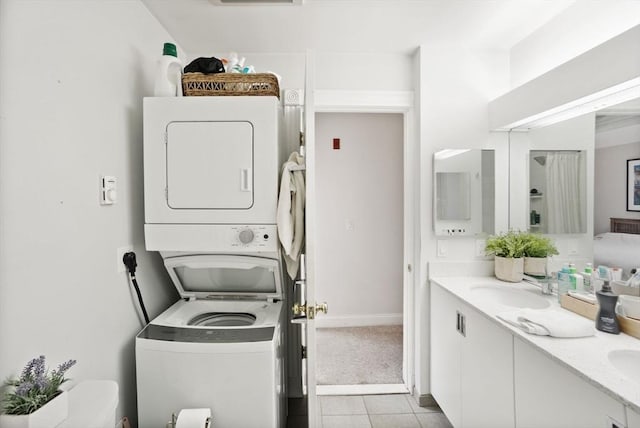 6 Brigham St Unit 2, Boston, MA 02128 - washroom with estacked washer and dryer, light tile patterned flooring, and baseboards