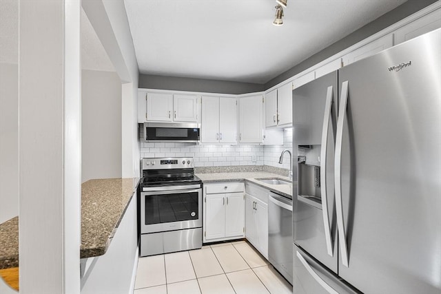 11 Cogswell Ave Unit 16, Cambridge, MA 02140 - kitchen with stainless steel appliances, a sink, decorative backsplash, and white cabinets