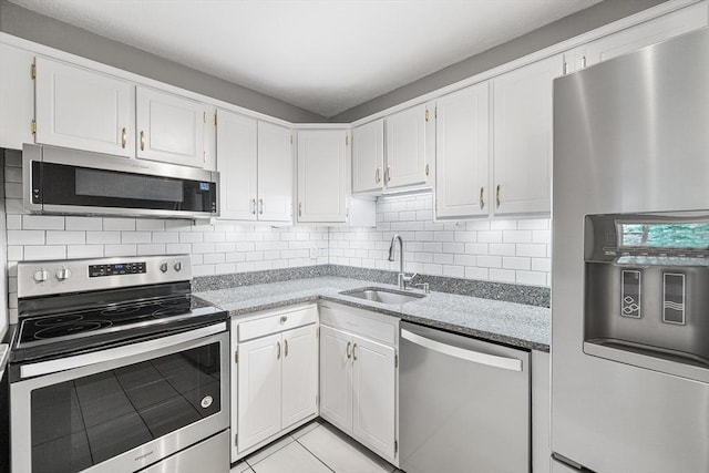 11 Cogswell Ave Unit 16, Cambridge, MA 02140 - kitchen featuring appliances with stainless steel finishes, a sink, white cabinets, and decorative backsplash