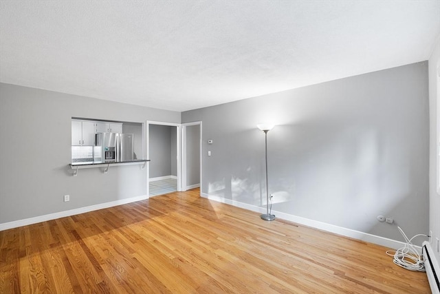 11 Cogswell Ave Unit 16, Cambridge, MA 02140 - spare room with a baseboard radiator, light wood-type flooring, and baseboards