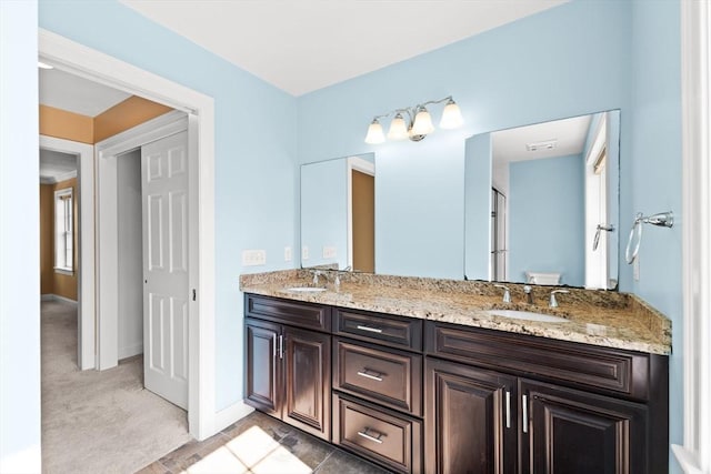 full bath with double vanity and baseboards