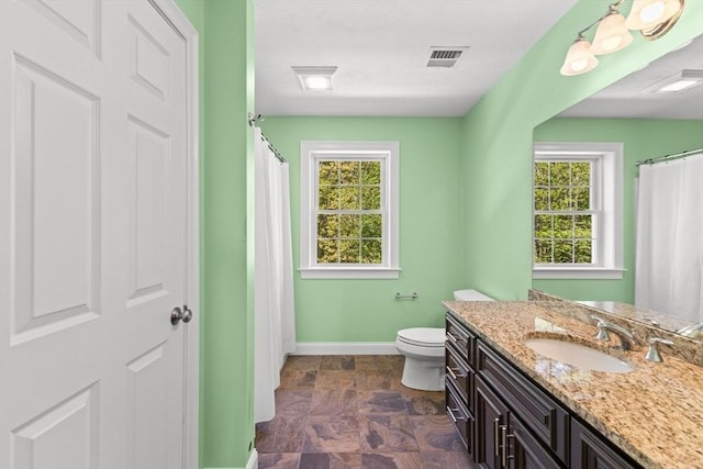 full bath with baseboards, healthy amount of natural light, toilet, and vanity