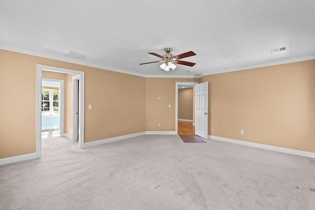 unfurnished room featuring ceiling fan, crown molding, light colored carpet, and baseboards