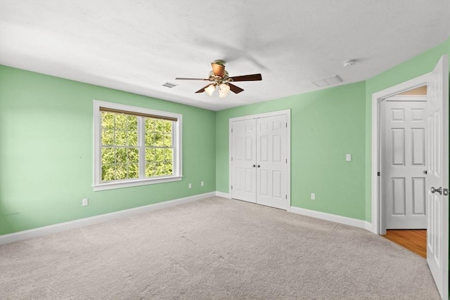 unfurnished bedroom featuring carpet floors, baseboards, a closet, and ceiling fan