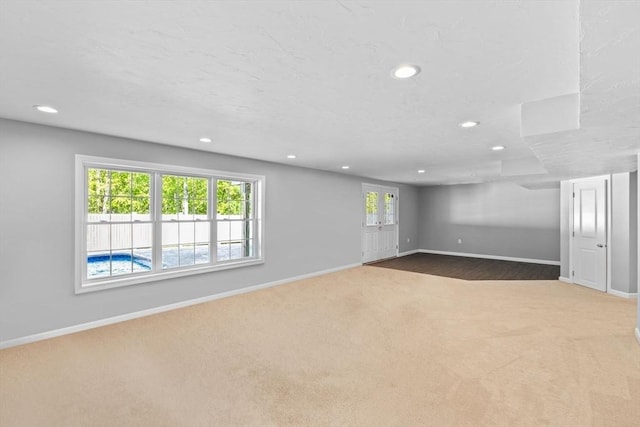 below grade area featuring carpet flooring, recessed lighting, and baseboards