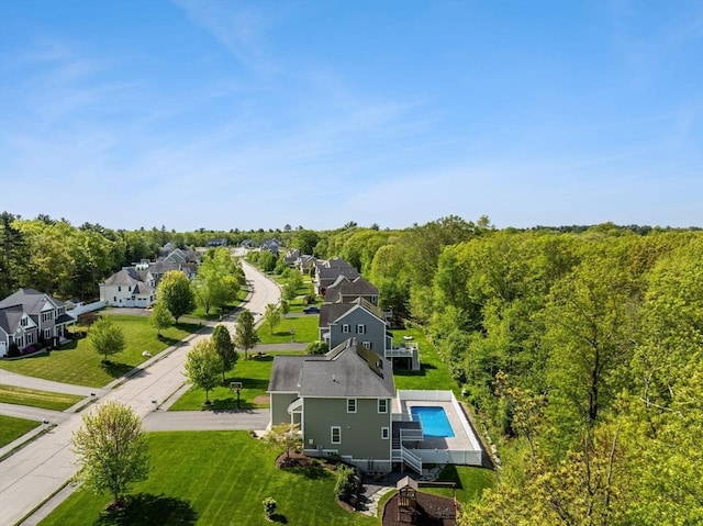 aerial perspective of suburban area with a pool area and a forest