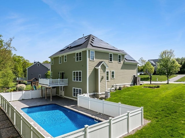 back of property with solar panels, central air condition unit, and a wooden deck