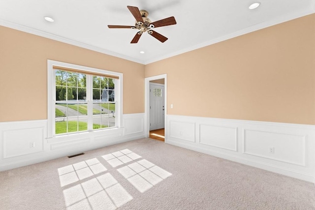 unfurnished room featuring light carpet, a wainscoted wall, crown molding, ceiling fan, and recessed lighting