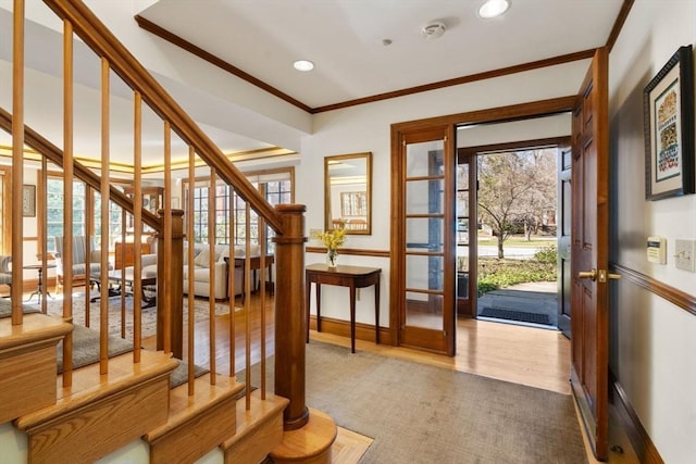 entryway featuring wood finished floors, recessed lighting, stairway, crown molding, and baseboards