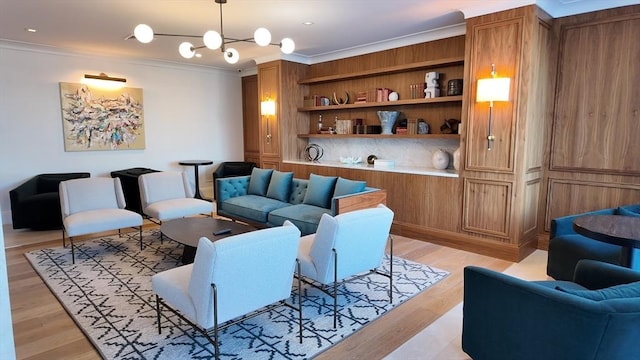 living room with light wood-type flooring, a chandelier, and crown molding