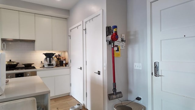 kitchen featuring tasteful backsplash, white cabinets, gas cooktop, and light hardwood / wood-style floors