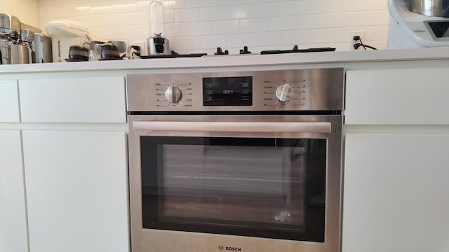 interior details featuring decorative backsplash and oven