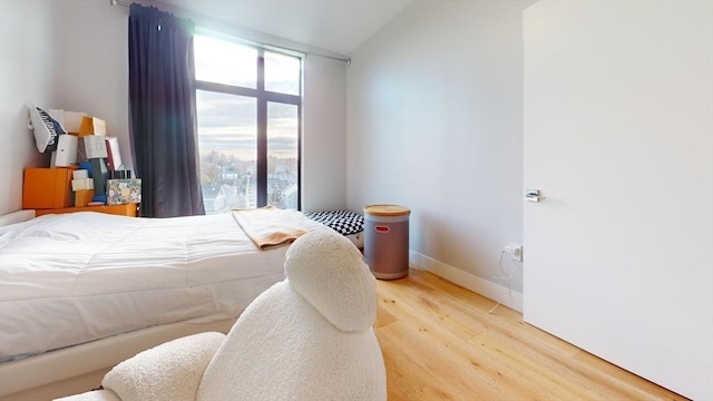 bedroom with lofted ceiling and hardwood / wood-style flooring