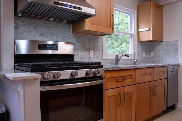 62 Roberts Dr Unit 62, Bedford, MA 01730 - kitchen featuring stainless steel appliances, wall chimney range hood, light stone counters, and tasteful backsplash