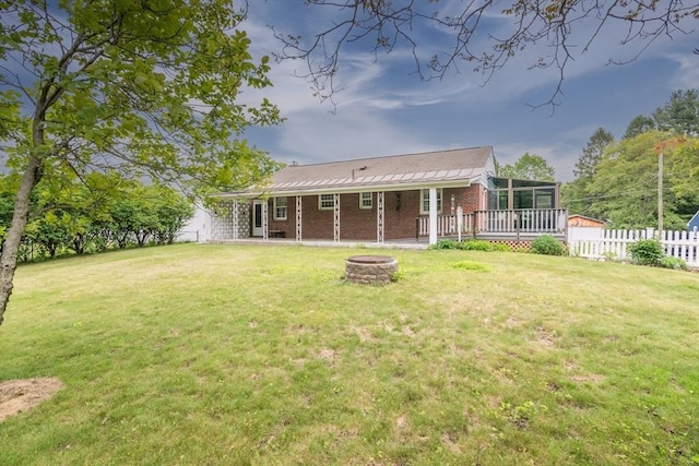 5 Norman Cir, Montague, MA 01376 - rear view of house featuring an outdoor fire pit, a sunroom, and brick siding