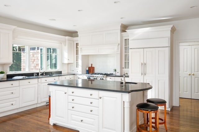 kitchen featuring white cabinetry, a kitchen island with sink, sink, and dark hardwood / wood-style floors