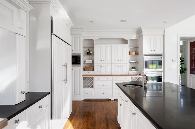 kitchen with dark hardwood / wood-style flooring, white cabinetry, sink, and appliances with stainless steel finishes