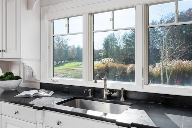 kitchen featuring white cabinets, a healthy amount of sunlight, and sink