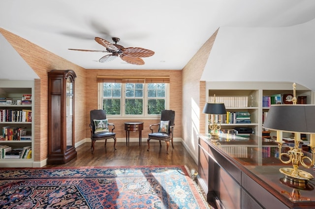 sitting room with ceiling fan and dark wood-type flooring